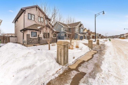 View of front facade with a residential view, stone siding, and stucco siding - 656 180 Street, Edmonton, AB - Outdoor With Facade