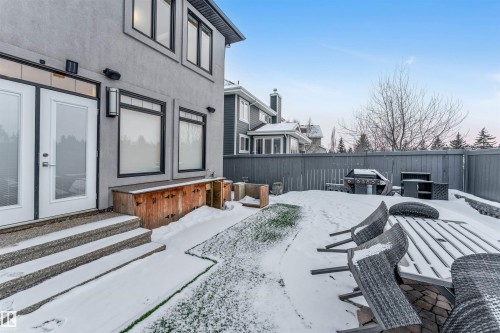 Snow covered patio with area for grilling, a fenced backyard, and entry steps - 656 180 Street, Edmonton, AB - Outdoor
