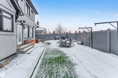 Yard covered in snow with a fenced backyard and a wooden deck - 656 180 Street, Edmonton, AB - Outdoor
