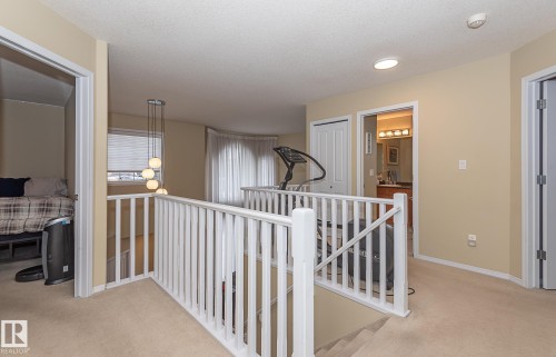 Hall with an upstairs landing, light colored carpet, and a textured ceiling - 20628 49 Avenue, Edmonton, AB - Indoor Photo Showing Other Room