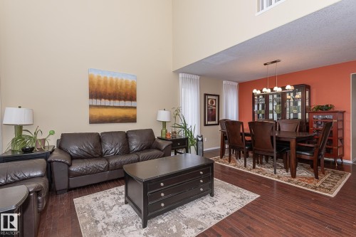 Living room with dark wood-style floors, a high ceiling, a chandelier, and a textured ceiling - 20628 49 Avenue, Edmonton, AB - Indoor Photo Showing Living Room