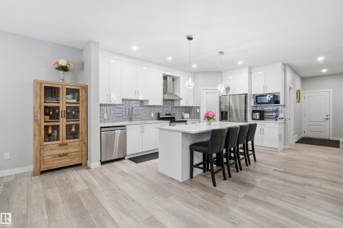 Kitchen featuring a breakfast bar, white cabinetry, a kitchen island, appliances with stainless steel finishes, and recessed lighting - 452 Roberts Crescent, Leduc, AB - Indoor Photo Showing Kitchen With Upgraded Kitchen