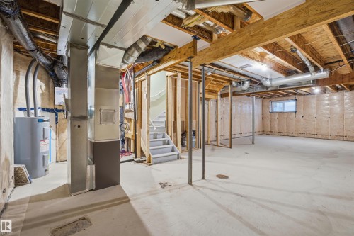 Below grade area with water heater, heating unit, and stairs - 452 Roberts Crescent, Leduc, AB - Indoor Photo Showing Basement