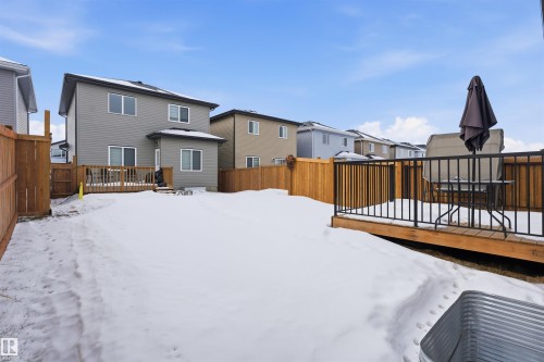Snow covered property with a deck, a fenced backyard, and a residential view - 452 Roberts Crescent, Leduc, AB - Outdoor With Exterior