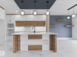 Kitchen with decorative light fixtures, a kitchen island with sink, light marble finish flooring, light stone counters, and recessed lighting - 