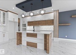 Kitchen featuring decorative light fixtures, light stone counters, light marble finish flooring, backsplash, and recessed lighting - 