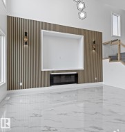 Unfurnished living room with marble tiled floors and a glass covered fireplace - 