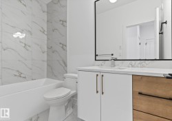 Full bath featuring vanity, shower / bath combination, and light marble finish floors - 