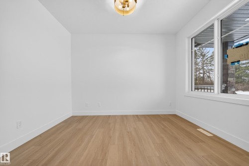 Unfurnished room with baseboards and light wood-style floors - 6115 Crawford Drive, Edmonton, AB - Indoor Photo Showing Other Room