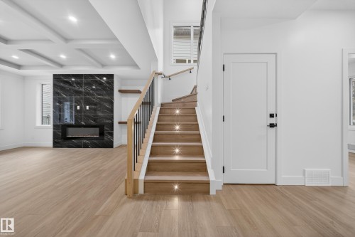 Staircase featuring coffered ceiling, beamed ceiling, wood finished floors, a premium fireplace, and recessed lighting - 6115 Crawford Drive, Edmonton, AB - Indoor Photo Showing Other Room With Fireplace