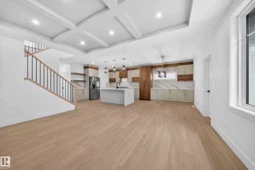 Unfurnished living room with light wood-style flooring, stairway, coffered ceiling, recessed lighting, and beamed ceiling - 6115 Crawford Drive, Edmonton, AB - Indoor