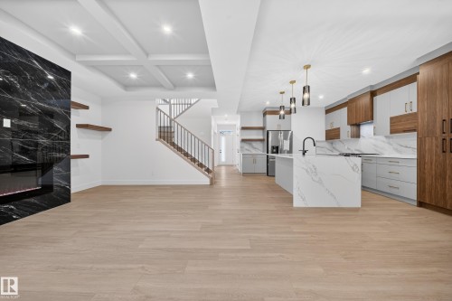 Kitchen featuring open shelves, coffered ceiling, hanging light fixtures, a center island with sink, and brown cabinets - 6115 Crawford Drive, Edmonton, AB - Indoor Photo Showing Kitchen With Fireplace With Upgraded Kitchen