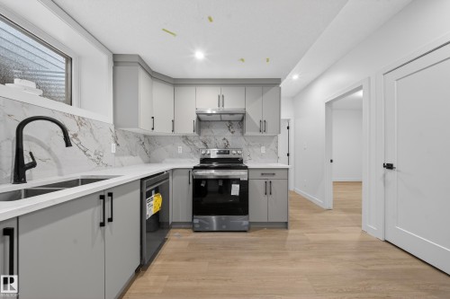 Kitchen featuring gray cabinets, light wood finished floors, electric range, light stone counters, and dishwashing machine - 6115 Crawford Drive, Edmonton, AB - Indoor Photo Showing Kitchen With Double Sink With Upgraded Kitchen