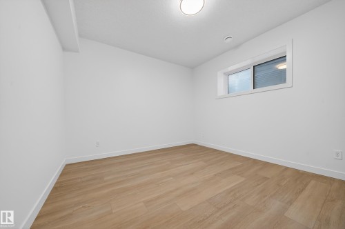 Spare room featuring light wood finished floors and lofted ceiling - 6115 Crawford Drive, Edmonton, AB - Indoor Photo Showing Other Room