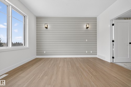 Spare room featuring light wood-style floors and wooden walls - 6115 Crawford Drive, Edmonton, AB - Indoor Photo Showing Other Room