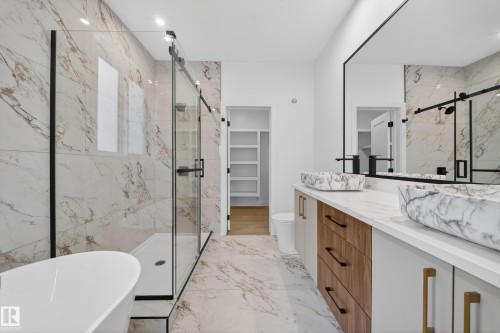 Bathroom with vanity, a walk in closet, a marble finish shower, a freestanding tub, and light marble finish floors - 6115 Crawford Drive, Edmonton, AB - Indoor Photo Showing Bathroom