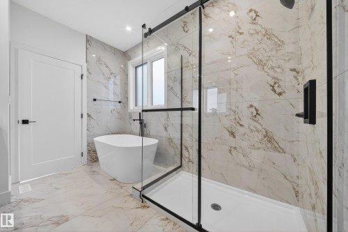 Bathroom featuring a marble finish shower, a freestanding tub, marble tiled floors, recessed lighting, and stone wall - 6115 Crawford Drive, Edmonton, AB - Indoor Photo Showing Bathroom