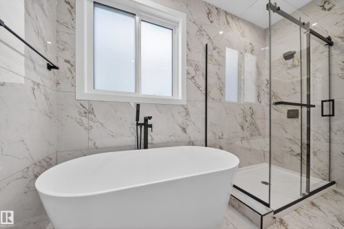 Full bathroom featuring marble tiled flooring, a marble finish shower, a freestanding tub, and stone wall - 6115 Crawford Drive, Edmonton, AB - Indoor Photo Showing Bathroom