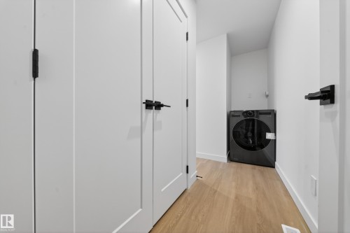 Laundry room featuring washer / clothes dryer and light wood-type flooring - 6115 Crawford Drive, Edmonton, AB - Indoor