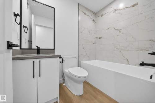 Full bath featuring vanity, washtub / shower combination, and light wood-style flooring - 6115 Crawford Drive, Edmonton, AB - Indoor Photo Showing Bathroom