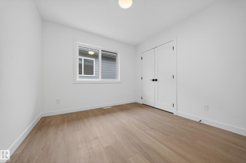 Unfurnished bedroom with light wood-type flooring and a closet - 6115 Crawford Drive, Edmonton, AB - Indoor Photo Showing Other Room