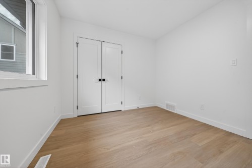 Unfurnished bedroom with light wood-style floors, a closet, and lofted ceiling - 6115 Crawford Drive, Edmonton, AB - Indoor Photo Showing Other Room