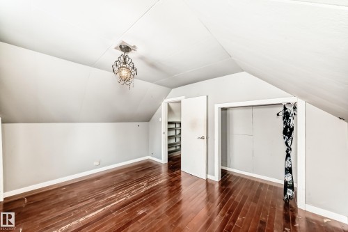 Bonus room featuring dark wood-style floors and vaulted ceiling - 10115 104, Westlock, AB - Indoor Photo Showing Other Room