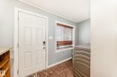 Laundry room with washer / clothes dryer, ornamental molding, and dark tile patterned floors - 10115 104, Westlock, AB  - Indoor 
