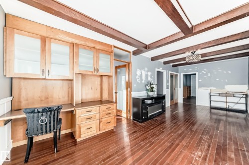 Office space featuring built in desk, beam ceiling, and dark wood-type flooring - 10115 104, Westlock, AB - Indoor