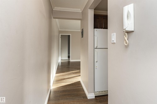 Hall featuring crown molding and dark wood finished floors - 102 10735 81 Avenue, Edmonton, AB - Indoor Photo Showing Other Room