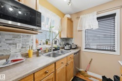 Kitchen with appliances with stainless steel finishes, light countertops, tasteful backsplash, a textured ceiling, and rail lighting - 