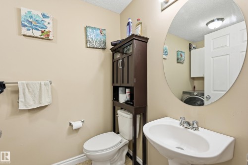 Half bathroom featuring a textured ceiling and washer / dryer - 3010 32 Avenue Nw, Edmonton, AB - Indoor Photo Showing Bathroom