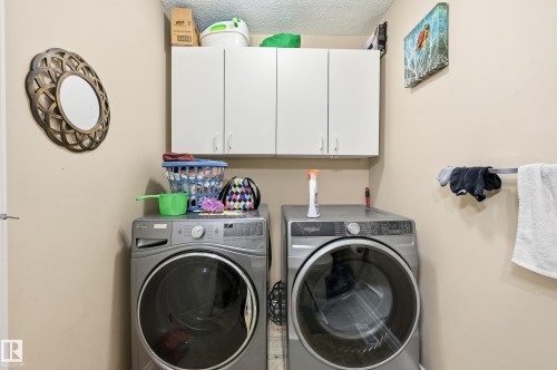 Washroom with cabinet space, a textured ceiling, and independent washer and dryer - 3010 32 Avenue Nw, Edmonton, AB - Indoor Photo Showing Laundry Room