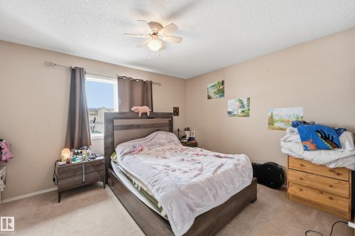 Bedroom with light colored carpet, ceiling fan, and a textured ceiling - 3010 32 Avenue Nw, Edmonton, AB - Indoor Photo Showing Bedroom