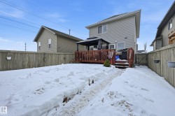 Snow covered house featuring a fenced backyard and a deck - 