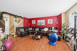 Living room featuring stairway, wood finished floors, plenty of natural light, and a textured ceiling - 