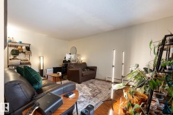 Living area featuring hardwood / wood-style flooring, a baseboard heating unit, and a textured ceiling - 