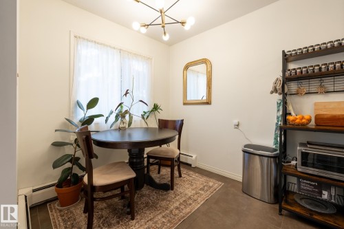 Dining room with a chandelier and a baseboard heating unit - 307 5730 Riverbend Road, Edmonton, AB - Indoor