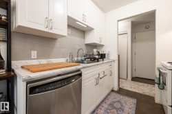 Kitchen with dishwasher, white cabinetry, light countertops, and white range - 