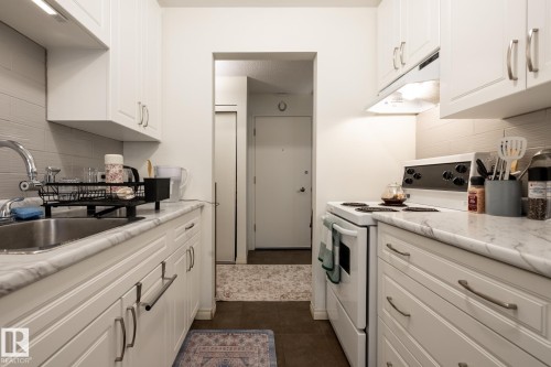 Kitchen featuring tasteful backsplash, white electric range oven, and white cabinets - 307 5730 Riverbend Road, Edmonton, AB - Indoor Photo Showing Kitchen