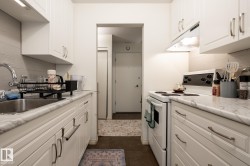 Kitchen featuring tasteful backsplash, white electric range oven, and white cabinets - 