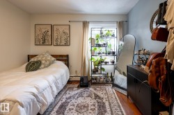 Bedroom with wood finished floors, a textured ceiling, and baseboard heating - 