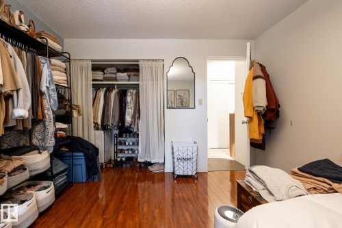Bedroom with a closet, hardwood / wood-style floors, and a textured ceiling - 307 5730 Riverbend Road, Edmonton, AB - Indoor With Storage
