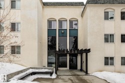 Snow covered property entrance with a shingled roof, stucco siding, and a patio area - 