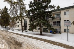 Snow covered building featuring a view of apartment building / complex - 