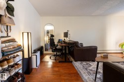Home office with dark wood-style flooring, a textured ceiling, and a baseboard heating unit - 