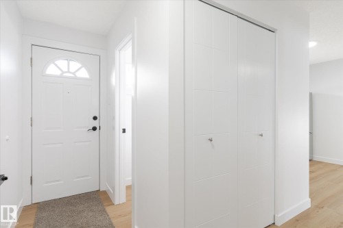 Foyer with light wood-style flooring and baseboards - 5105 106A Street, Edmonton, AB - Indoor Photo Showing Other Room