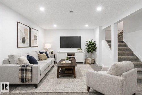 Living area featuring carpet flooring, stairs, a textured ceiling, and recessed lighting - 5105 106A Street, Edmonton, AB - Indoor Photo Showing Living Room