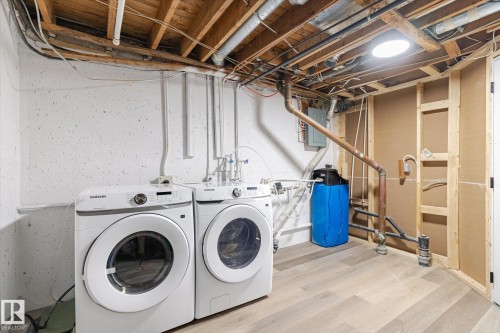 Laundry area with washing machine and clothes dryer, wood finished floors, and electric panel - 5105 106A Street, Edmonton, AB - Indoor Photo Showing Laundry Room