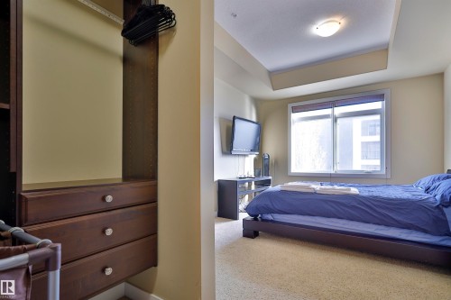 Carpeted bedroom with a raised ceiling - 203 9908 84 Avenue, Edmonton, AB - Indoor Photo Showing Bedroom